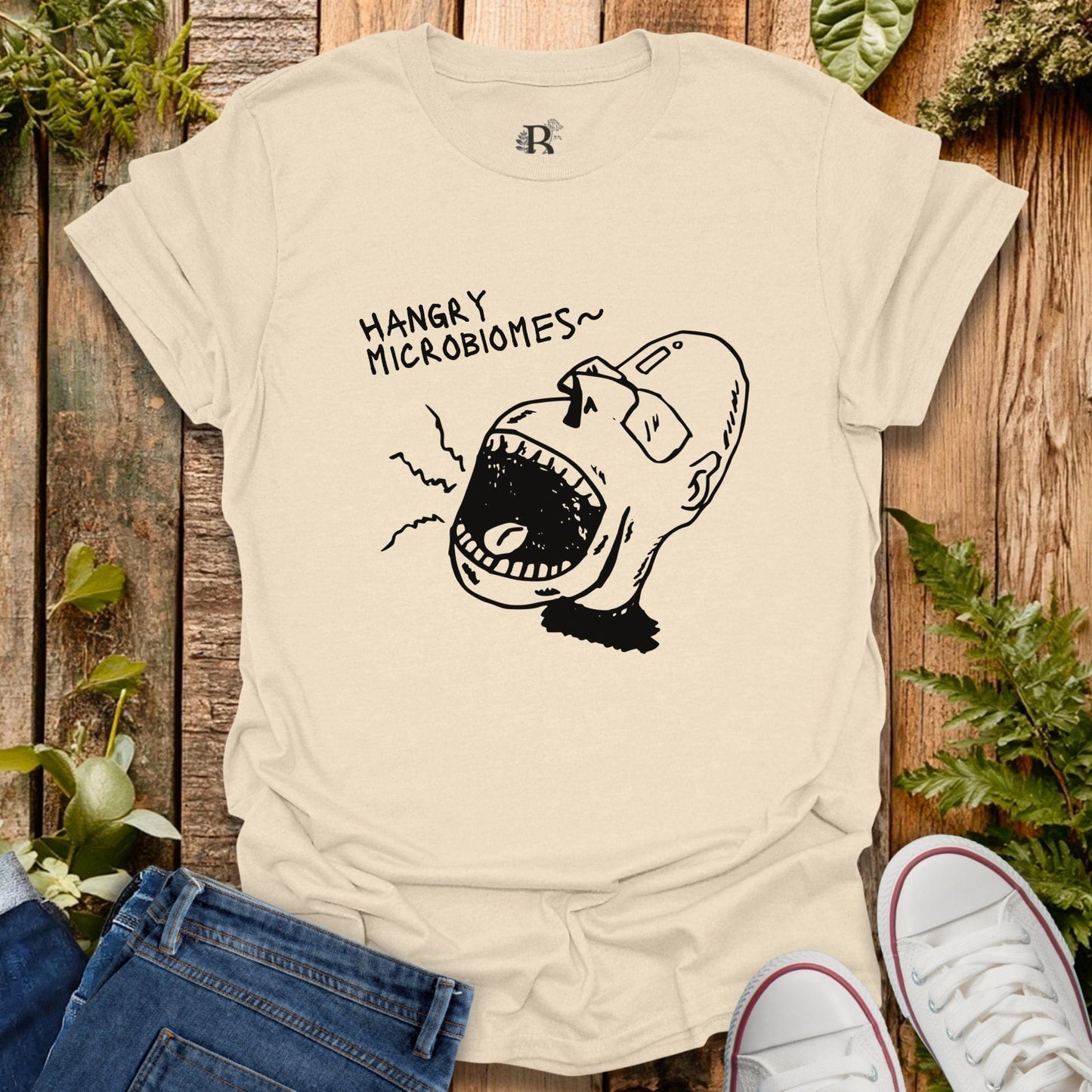 Beige t-shirt with a graphic design and text on a wooden background