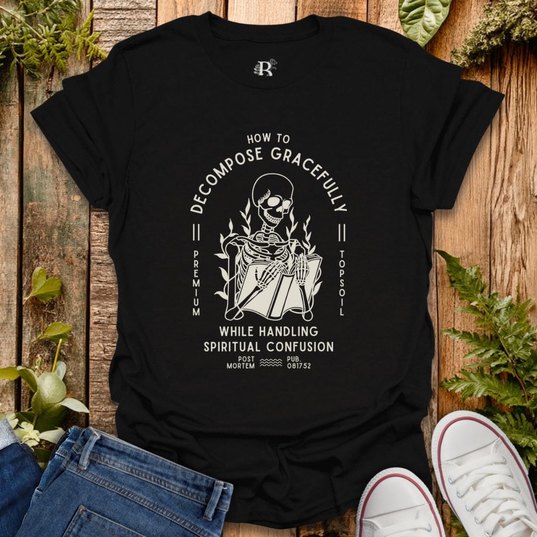 Black t-shirt with a skeleton graphic design on a wooden surface with plants