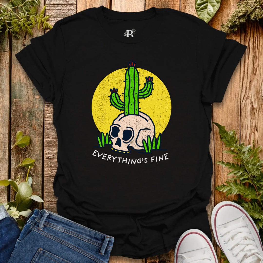 Black t-shirt with a skull and cactus design and 'Everything's Fine' text on a wooden surface with plants.