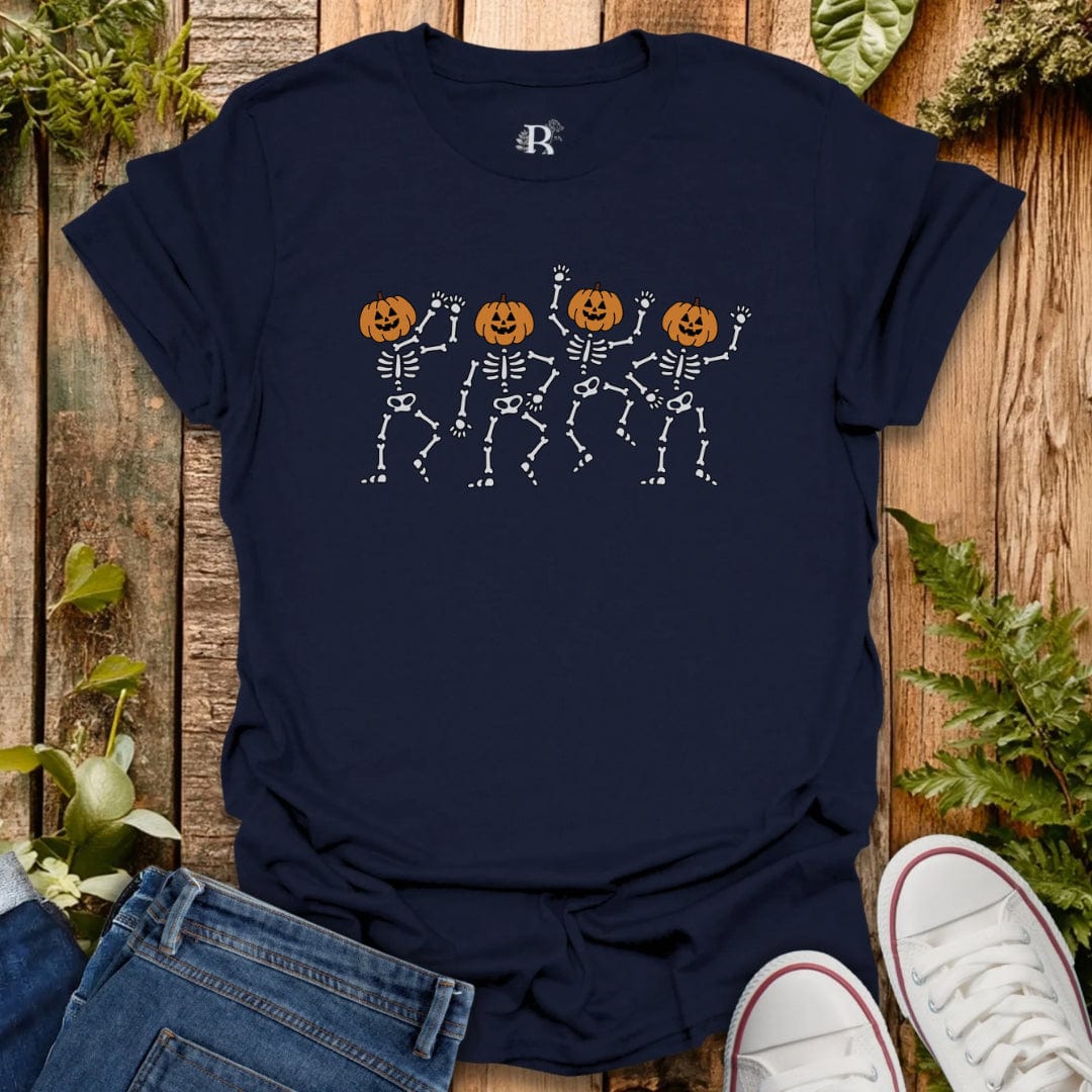 Navy blue t-shirt with skeleton and pumpkin design on a wooden surface with jeans and white sneakers.