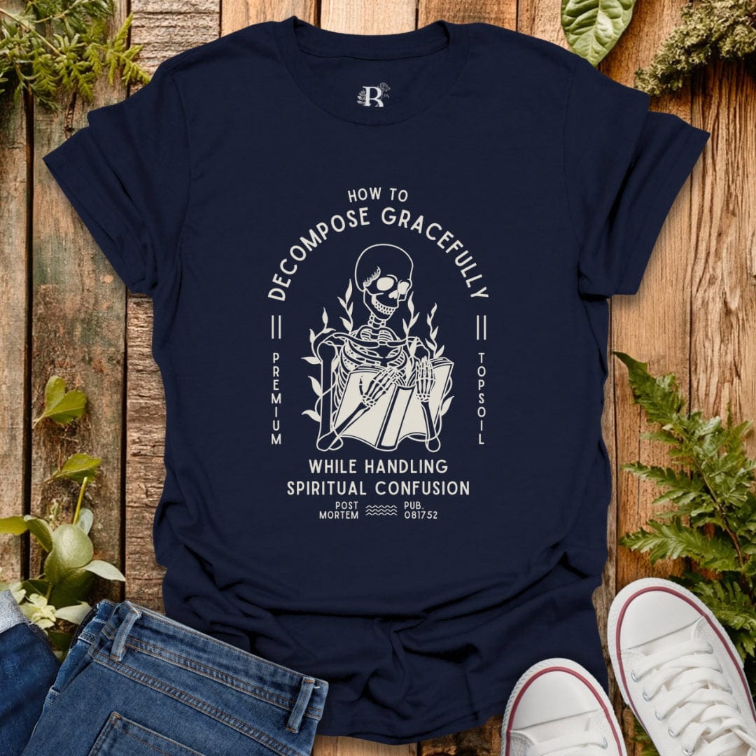 Navy blue t-shirt with a graphic design on a wooden surface with plants.