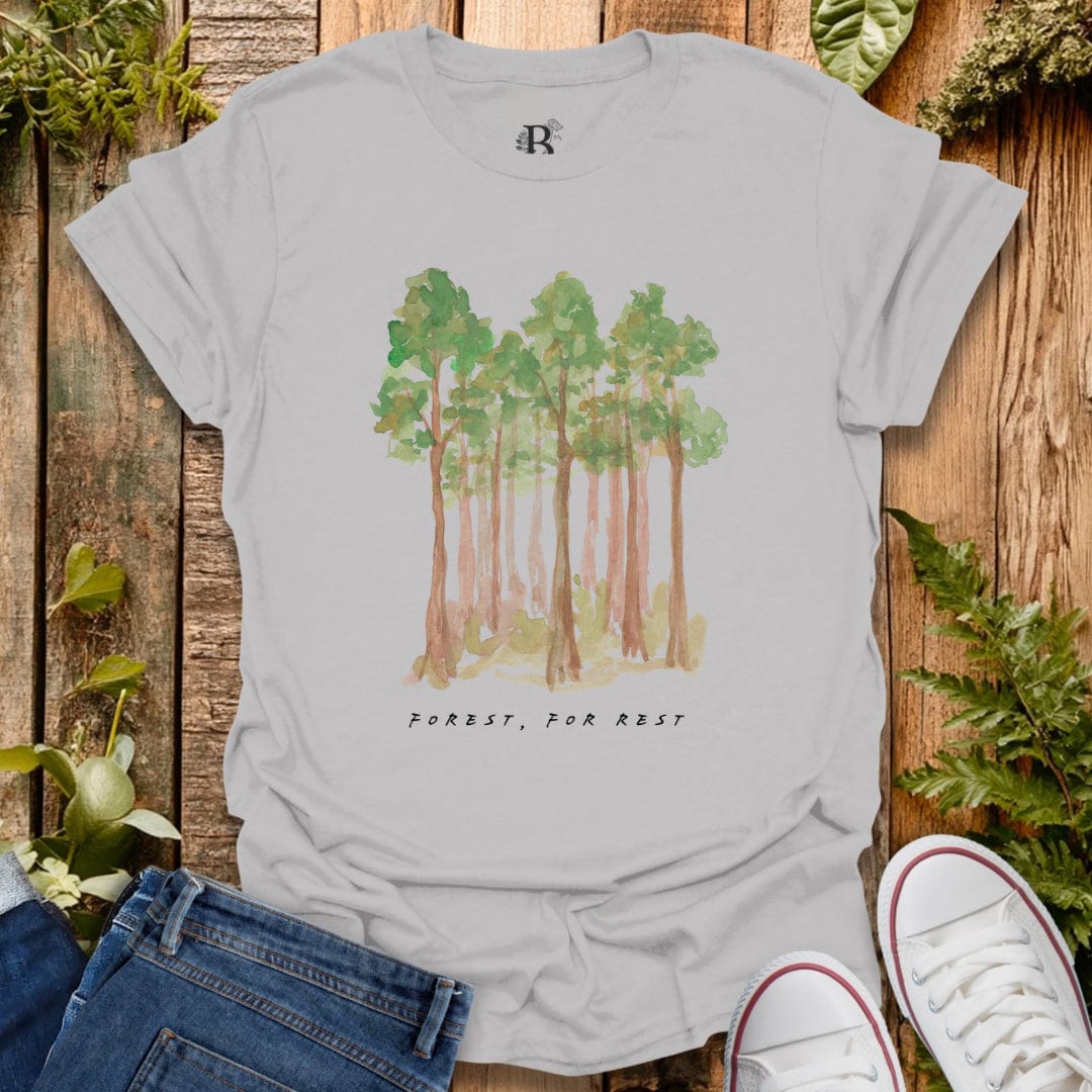 Gray t-shirt with forest design and text on a wooden background