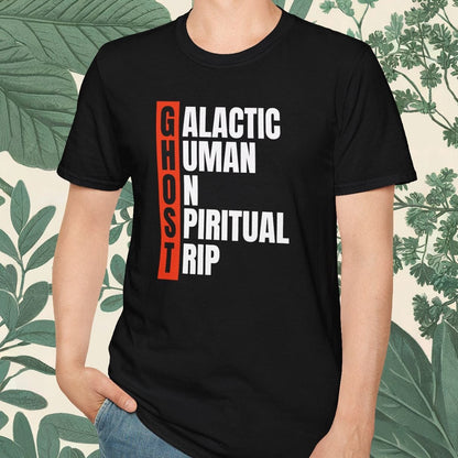 Person wearing a black t-shirt with text design, standing against a leafy background