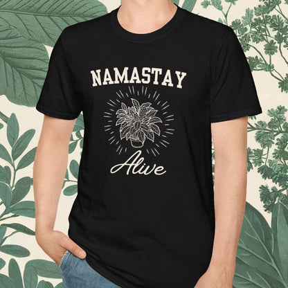 Person wearing a black t-shirt with 'NAMASTAY Alive' design against a leafy background