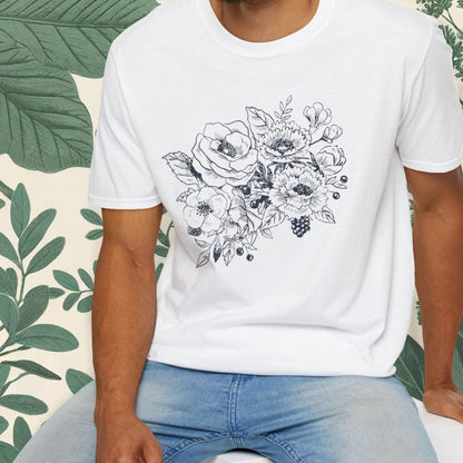 Man wearing a white t-shirt with floral design sitting on a white stool against a green leafy background