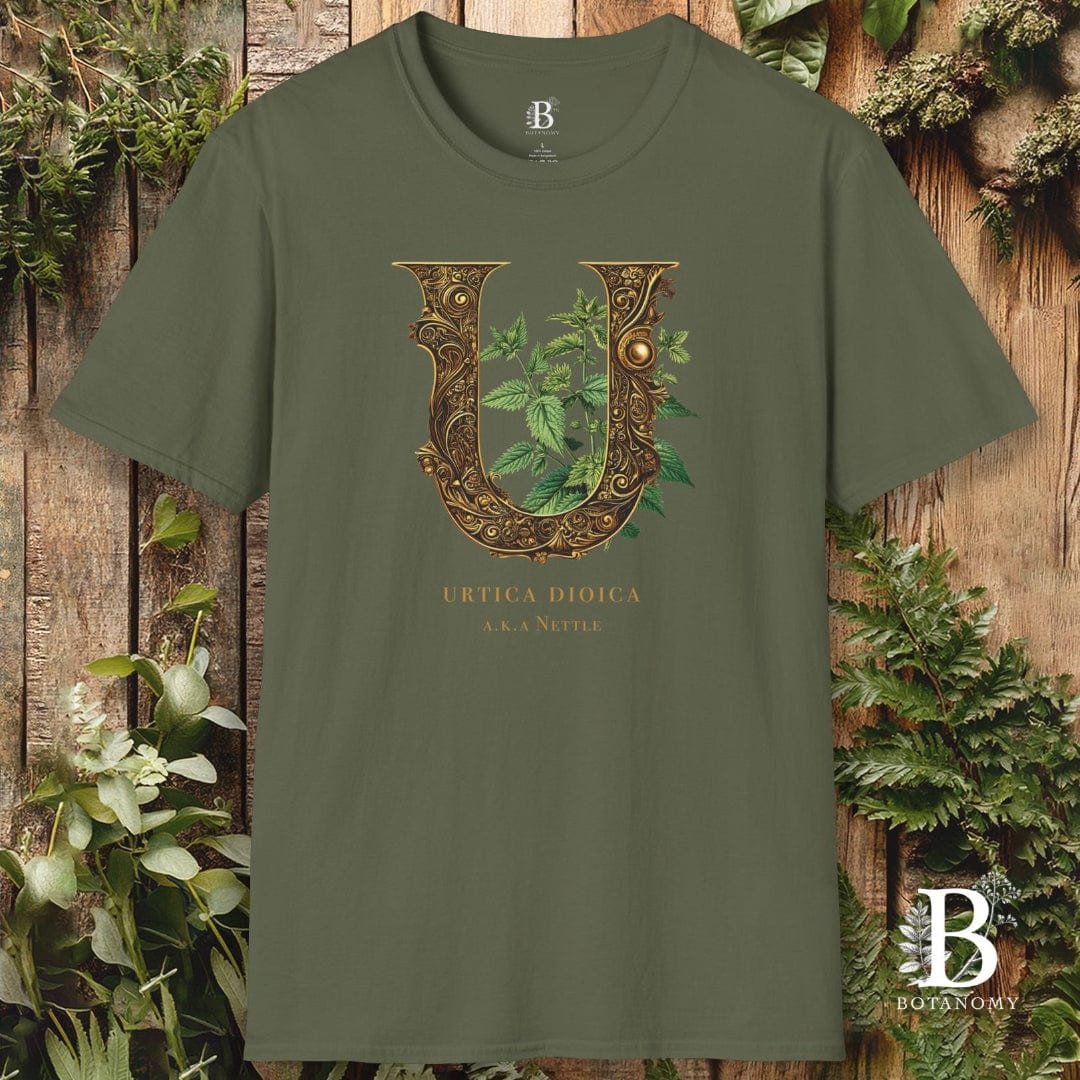 Green t-shirt with decorative letter 'U' design on a wooden background with plants