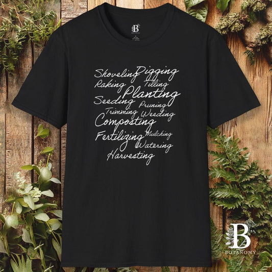 Black t-shirt with gardening-themed text on a wooden background with plants