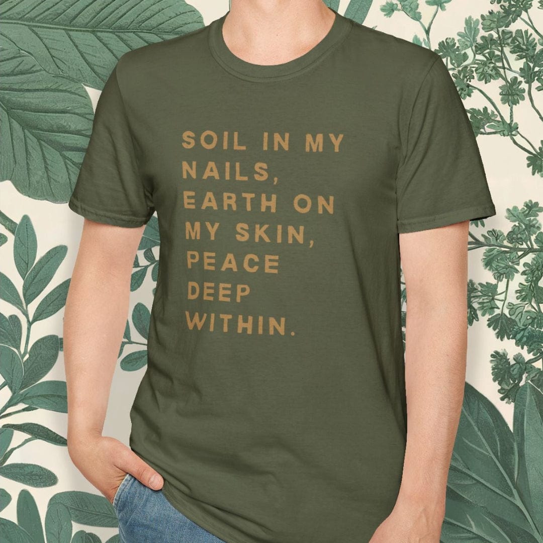 Person wearing a green t-shirt with text, standing against a leafy background