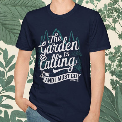 Person wearing a navy blue t-shirt with text and graphic design, standing against a leafy background.