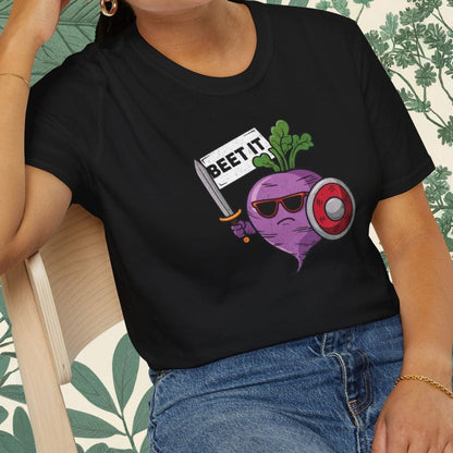 Person wearing a black t-shirt with a graphic design sitting on a chair.