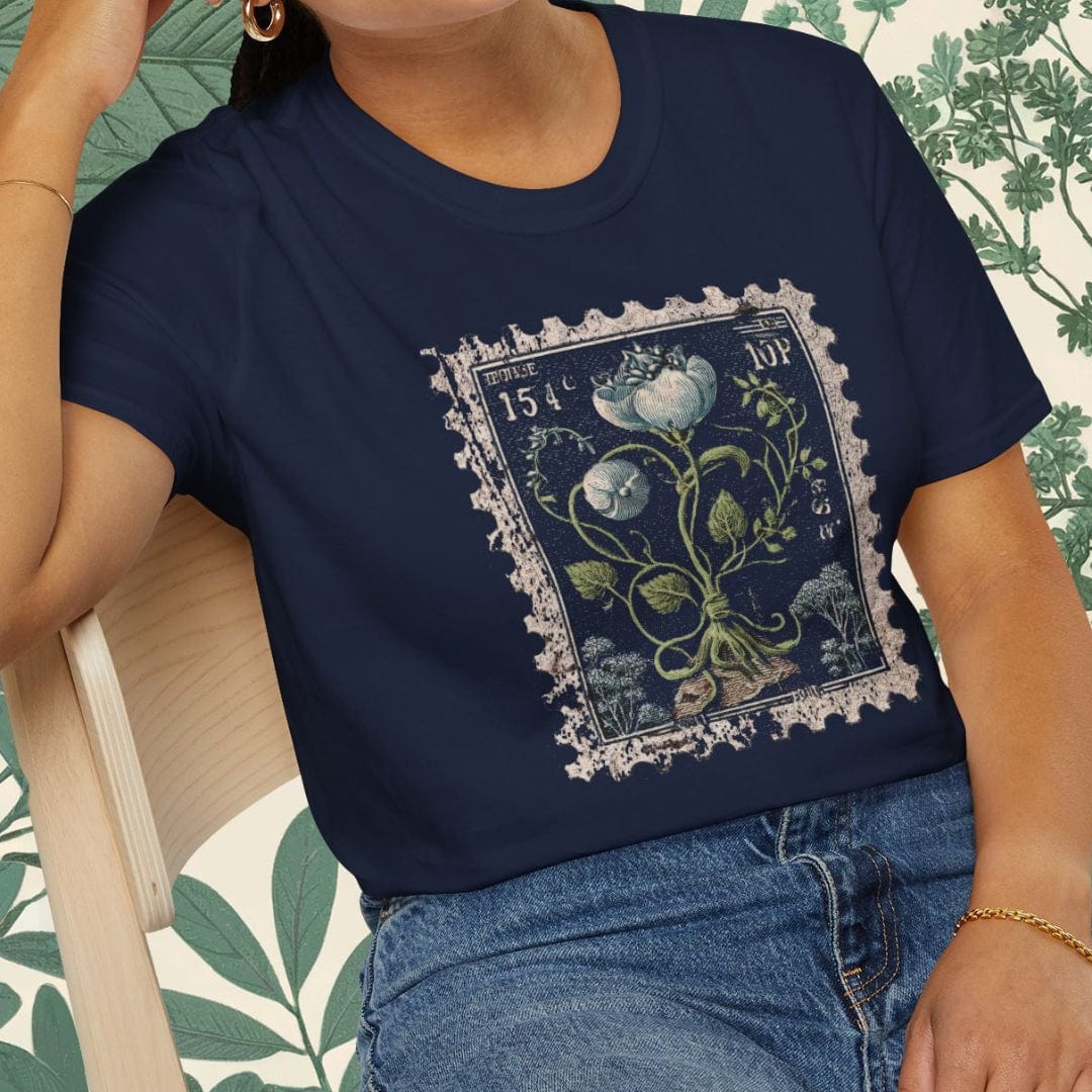 Woman wearing a navy blue t-shirt with floral design sitting on a chair.