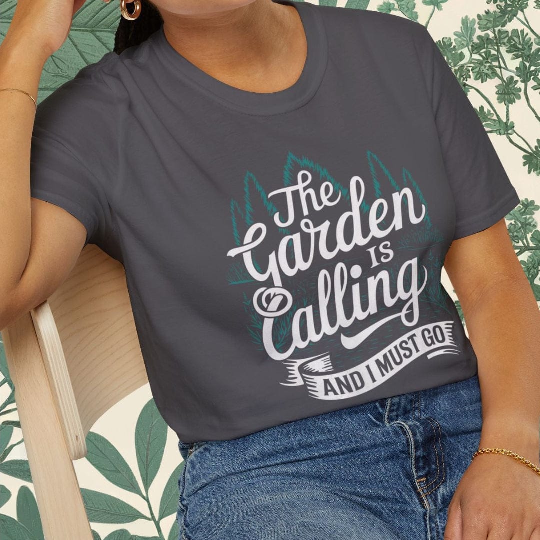 Woman wearing a gray t-shirt with 'The Garden is Calling' text, sitting on a chair.