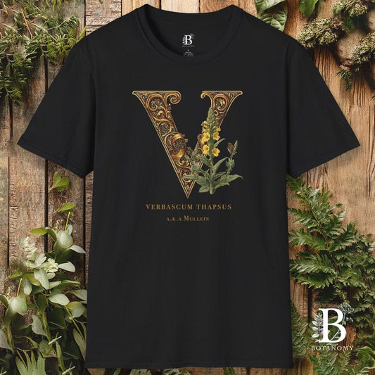 Black t-shirt with decorative letter 'V' and plant design on a wooden background