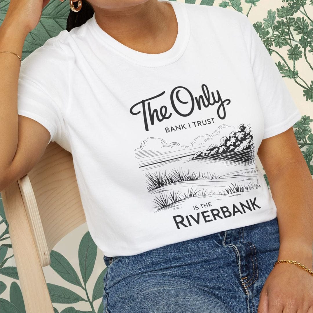 Person wearing a white t-shirt with text and graphics, sitting on a chair.