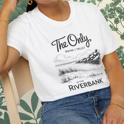 Person wearing a white t-shirt with text and graphics, sitting on a chair.