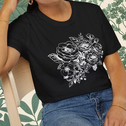 Woman wearing a black t-shirt with floral design sitting on a chair.