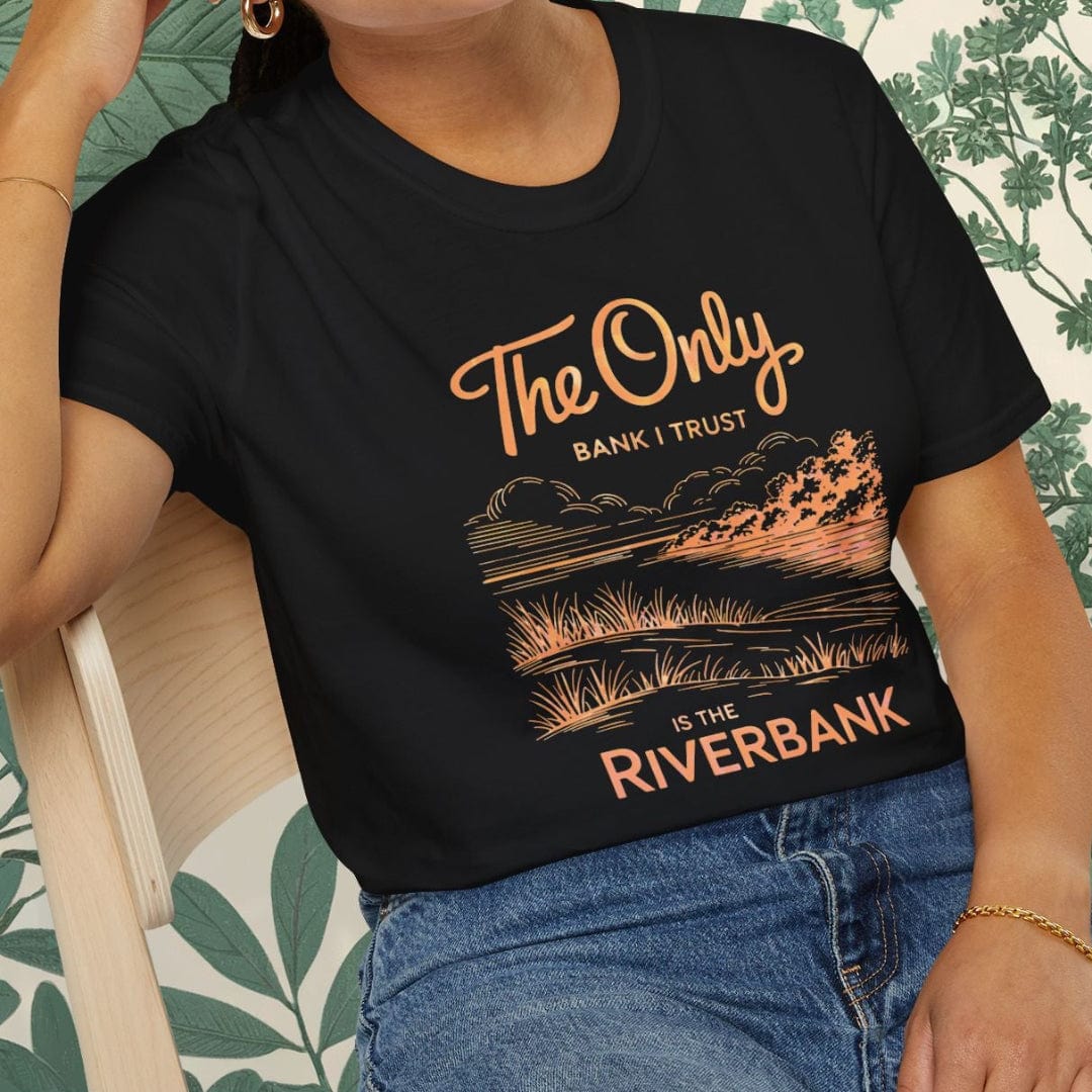 Person wearing a black t-shirt with a graphic design and text, sitting on a chair.