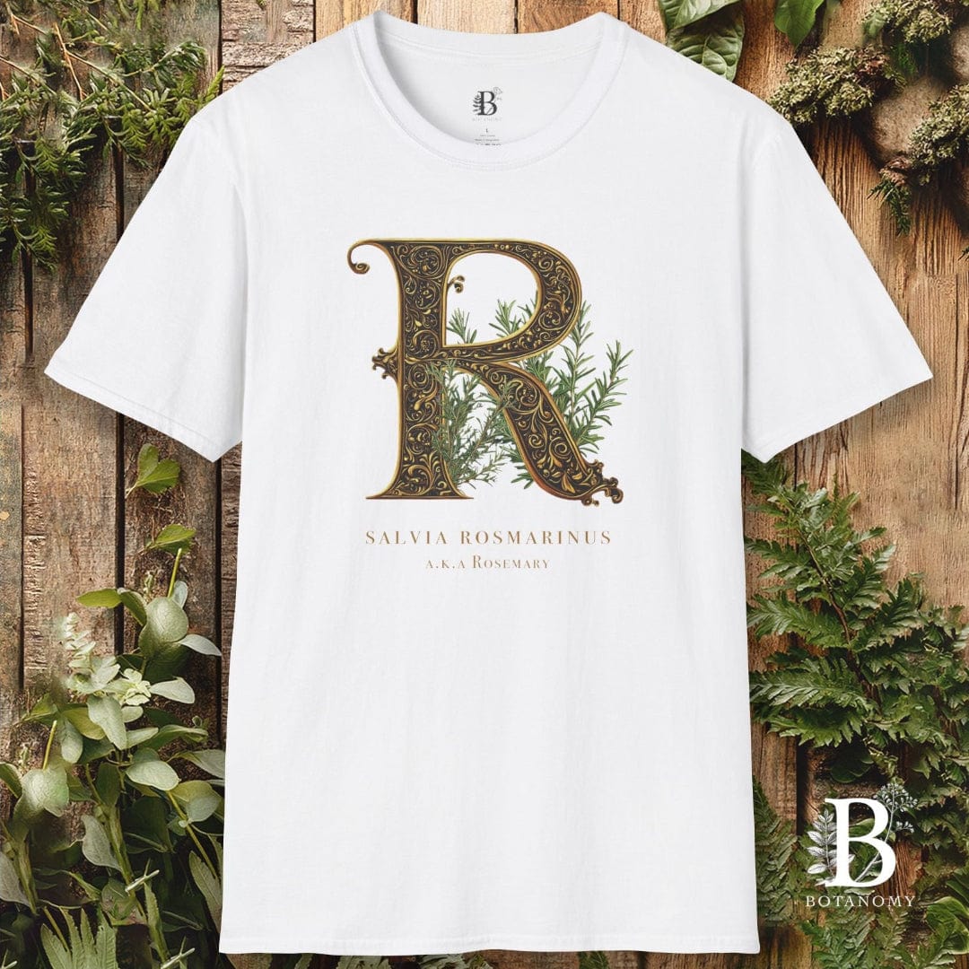 White t-shirt with decorative letter 'R' design on a wooden background with plants