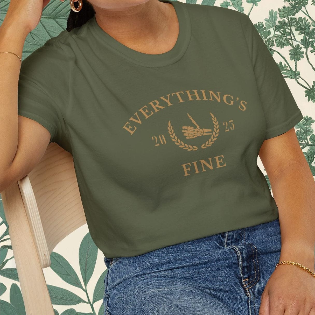 Woman wearing a green t-shirt with text, sitting on a chair with a floral background