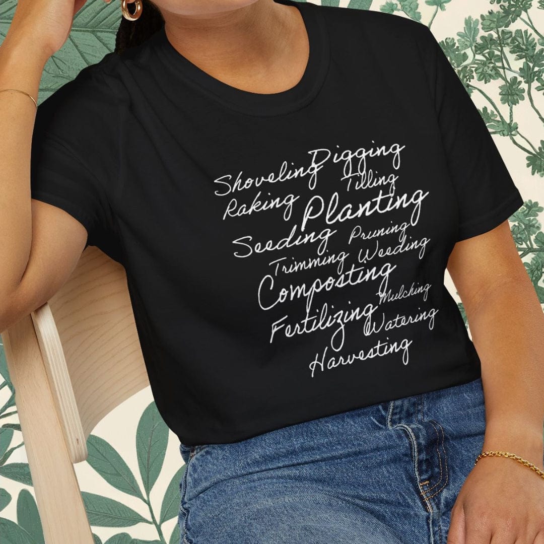 Woman wearing a black t-shirt with text, sitting on a chair with a leafy background