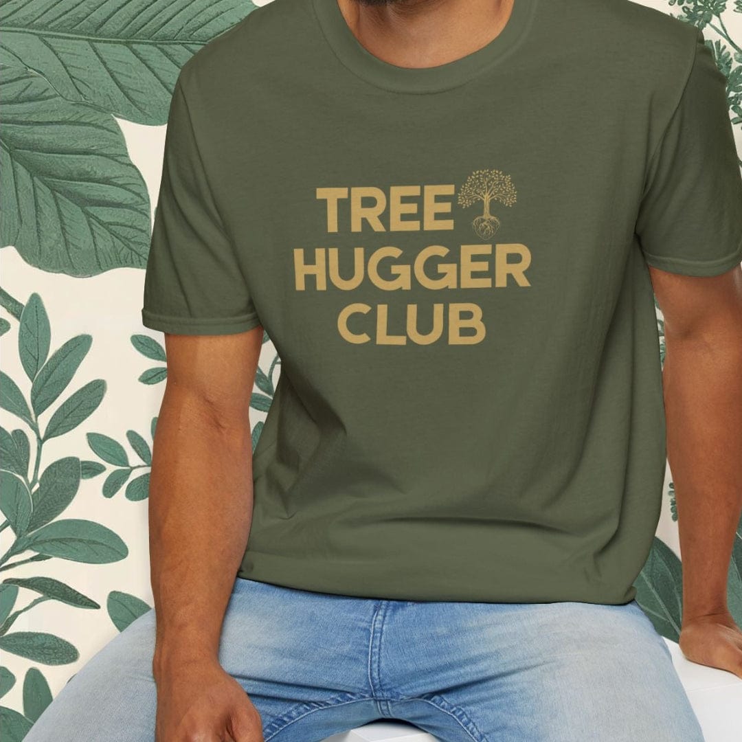 Man wearing a green t-shirt with 'Tree Hugger Club' text, sitting on a white stool with a leafy background.