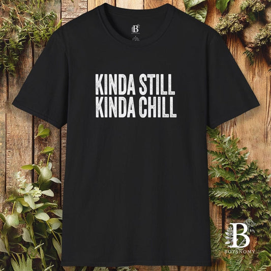 Black t-shirt with 'KINDA STILL KINDA CHILL' text on a wooden background