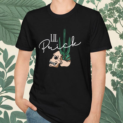 Person wearing a black t-shirt with a graphic design and text, standing against a leafy background.