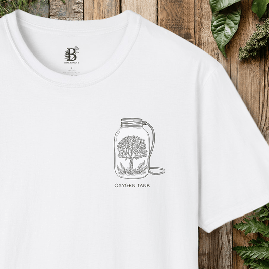 White t-shirt with a graphic design of a mason jar with a tree and 'Oxygen Tank' text, against a wooden background.
