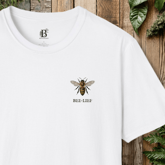 White t-shirt with bee design and 'Bee-Lief' text on a wooden background