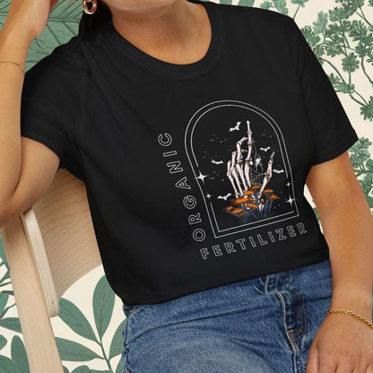 Person wearing a black t-shirt with graphic design sitting on a chair.