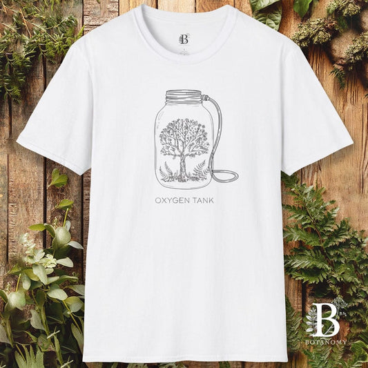 White t-shirt with 'Oxygen Tank' design on a wooden background with plants