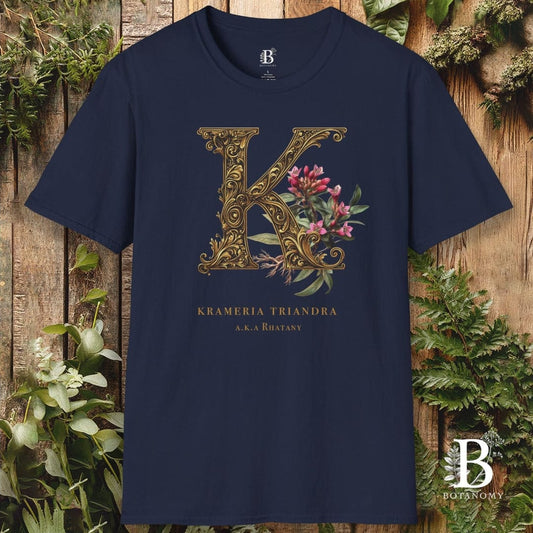 Navy blue t-shirt with decorative 'K' design on a wooden background
