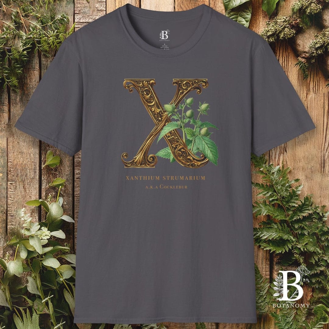 Gray t-shirt with decorative letter 'X' design on a wooden background with plants