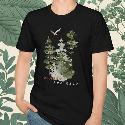Person wearing a black t-shirt with a nature graphic and text, standing against a leafy background.