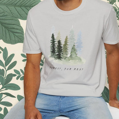 Man wearing a gray t-shirt with a nature graphic and text, sitting on a white stool.