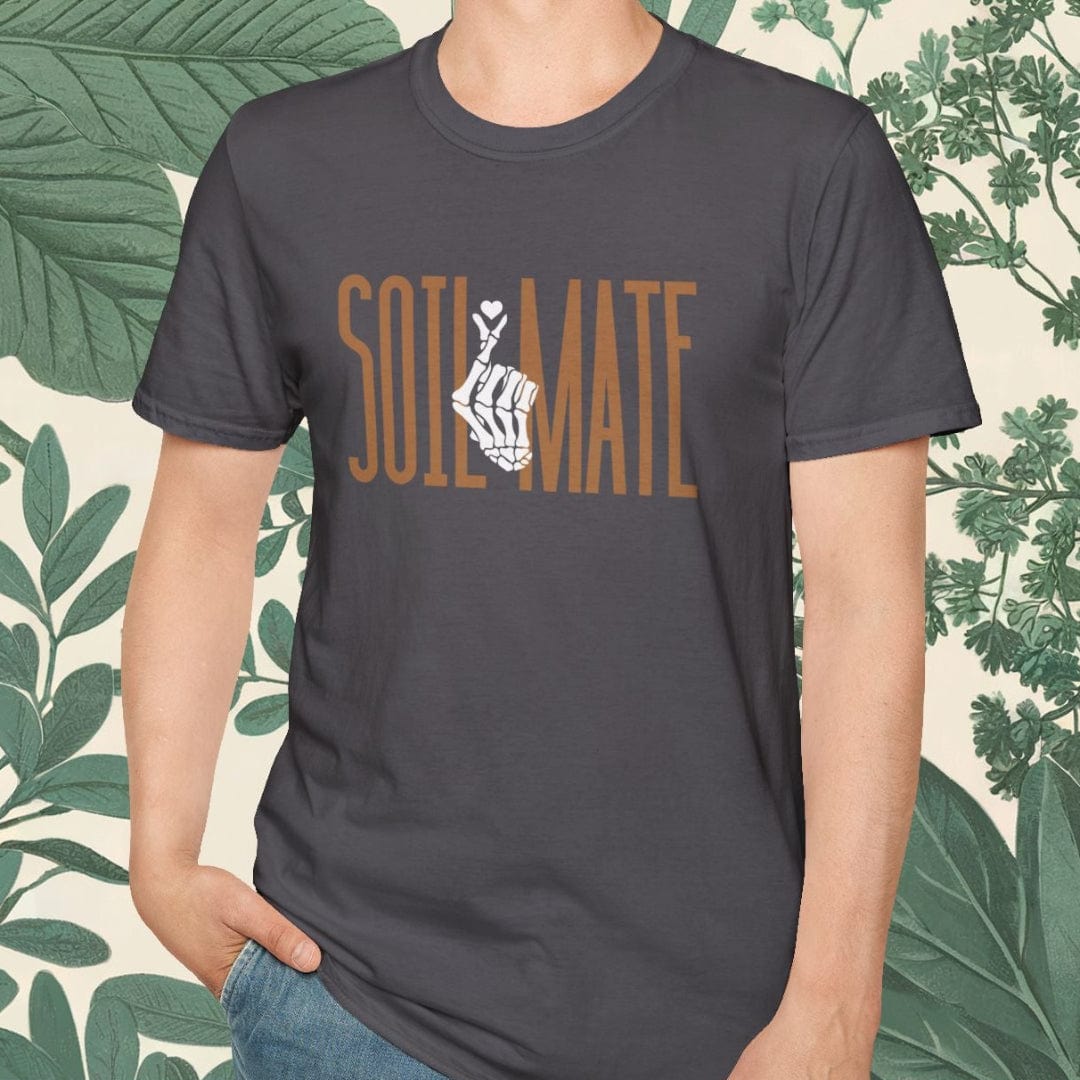 Man wearing a dark gray t-shirt with 'SOLI MATE' text, standing against a leafy background.