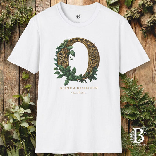 White t-shirt with decorative letter 'Q' design on a wooden background with plants