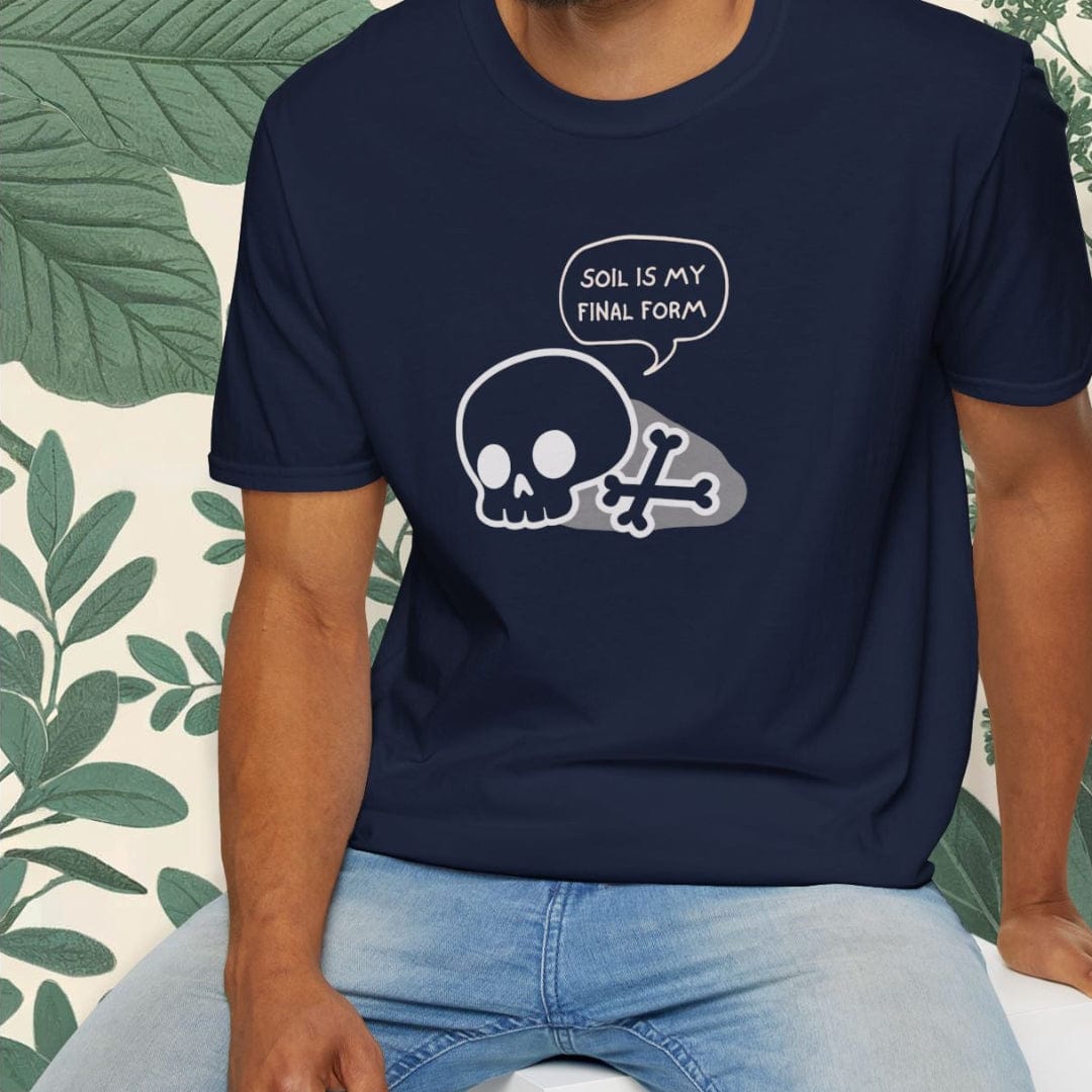 Man wearing a navy blue t-shirt with a skull design and text, sitting on a white stool with a green leafy background.