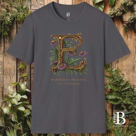 Gray t-shirt with decorative letter 'E' design featuring plants on a wooden background