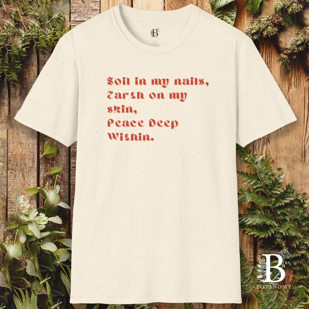 White t-shirt with red text on a wooden background with greenery