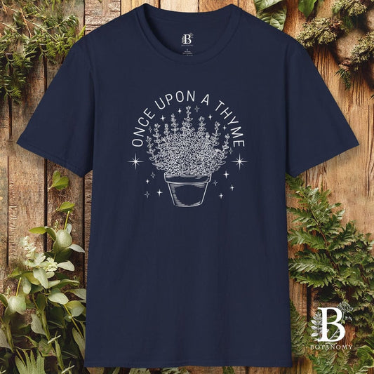 Navy blue t-shirt with 'Once Upon a Thyme' design on a wooden background with plants.