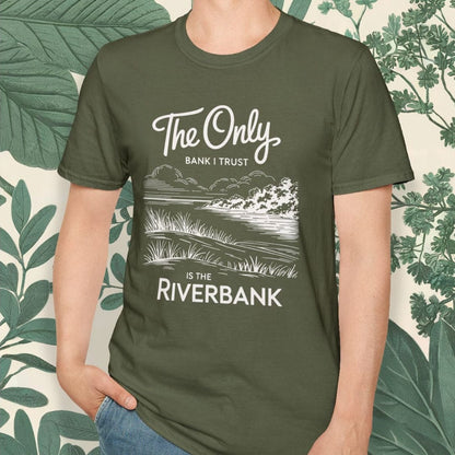 Person wearing a green t-shirt with a nature-themed design and text, standing against a leafy background.