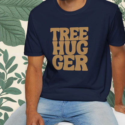 Man wearing a navy blue t-shirt with 'TREE HUGGER' text, sitting on a white stool with a green leafy background.