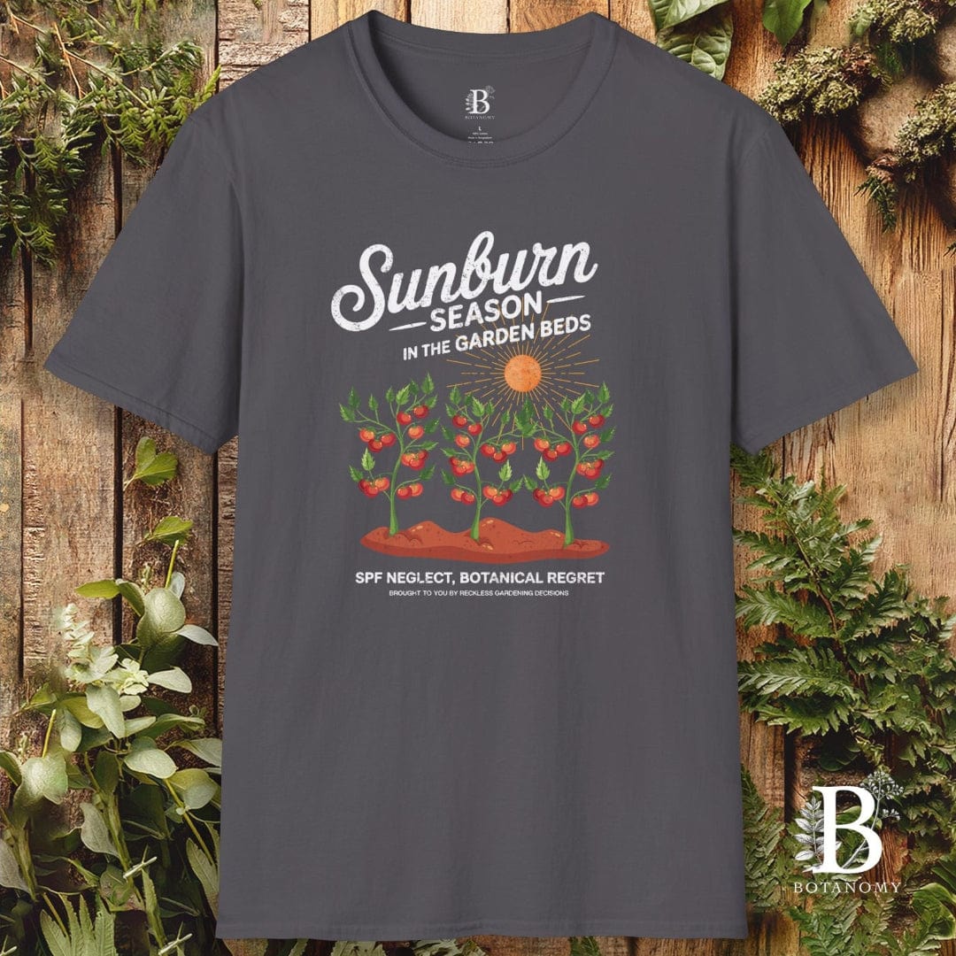 Gray t-shirt with garden-themed design and brand logo on a wooden background