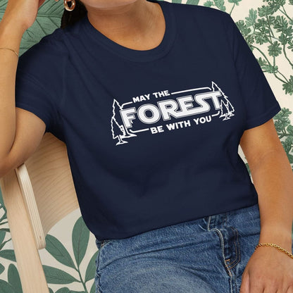 Person wearing a navy blue t-shirt with 'May the Forest be with you' text, sitting on a chair.