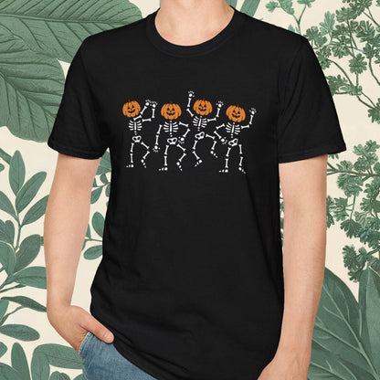 Person wearing a black t-shirt with skeleton and pumpkin design, standing against a leafy background.
