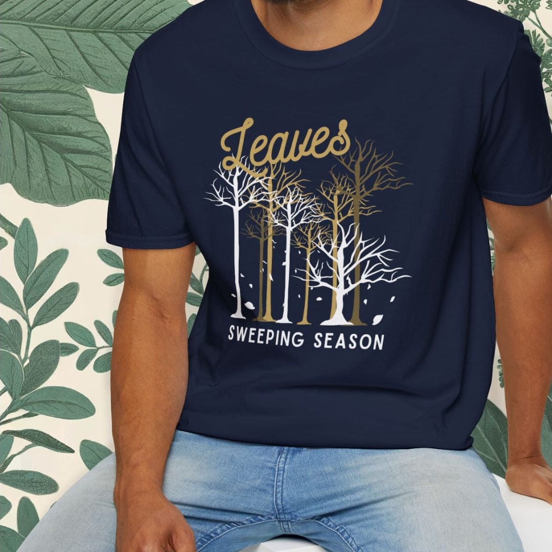 Man wearing a navy blue t-shirt with a forest design and text, sitting on a white stool.