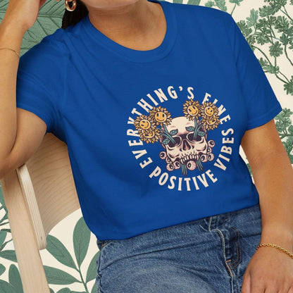 Person wearing a blue t-shirt with a graphic design and text, sitting on a chair.