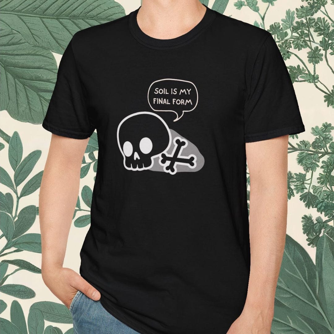 Person wearing a black t-shirt with a skull design and text, standing against a leafy background.