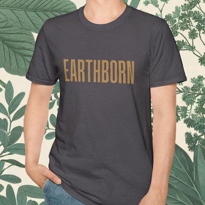 Person wearing a dark gray t-shirt with 'EARTHBORN' printed on it, standing against a leafy background.
